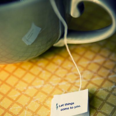 Green mug with hot tea with teabag words of wisdom